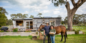 Beatrice and Peter standing in front of thier horse and on-site accommodation