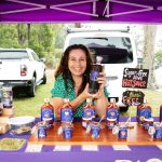 Owner of Pickle My Chili sitting at market stall with her chili sauces