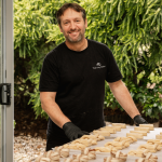 Grego with pastries on the table in front of him